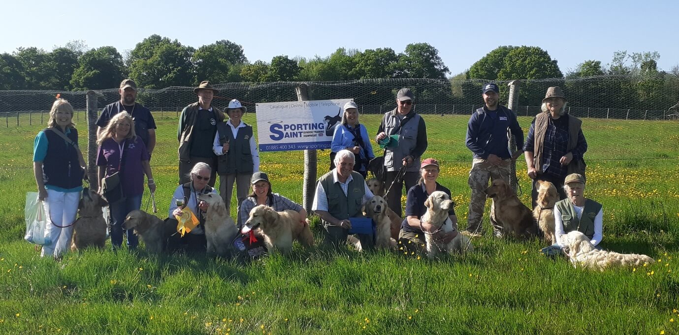 A group of people standing in a field with a sign Description automatically generated with low confidence