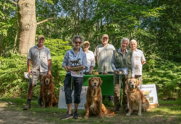 A group of people standing in front of a table with dogs Description automatically generated